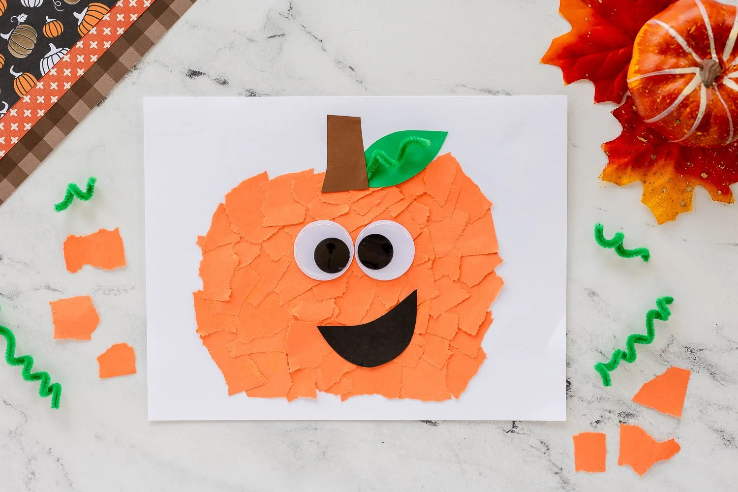 Torn paper pumpkin craft project showcasing vibrant autumn colors